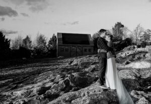 Couple kissing with the barn on The Land behind them